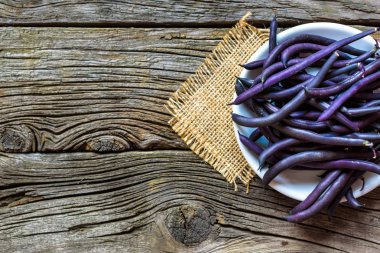 Ahşap ahşap arka plan tabağa mor dize fasulye.