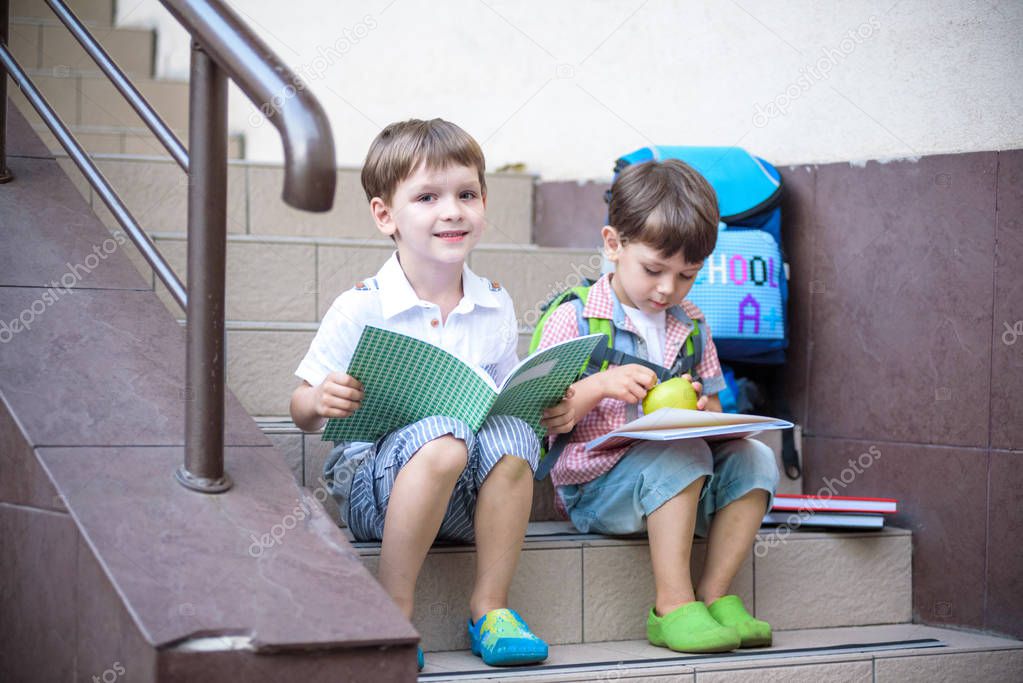 Children go back to school. Start of new school year after vacation. Two Boy friends with backpack and books on first school day. Beginning of class. Education for kindergarten and preschool kids.