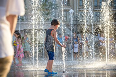 Kiev, Ukrayna 13 Ağustos 2017: Happy kids sıcak yaz gününde şehir su fıskiyede oynamak eğlenceli. Ebeveynler çocuklarıyla birlikte. Etkin aile boş, ekoloji kavramı.