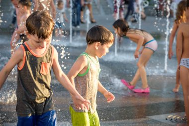 Kiev, Ukrayna 13 Ağustos 2017: Happy kids sıcak yaz gününde şehir su fıskiyede oynamak eğlenceli. Ebeveynler çocuklarıyla birlikte. Etkin aile boş, ekoloji kavramı.
