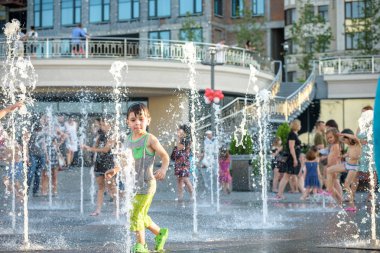 Kiev, Ukrayna 13 Ağustos 2017: Happy kids sıcak yaz gününde şehir su fıskiyede oynamak eğlenceli. Ebeveynler çocuklarıyla birlikte. Etkin aile boş, ekoloji kavramı.