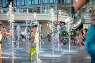 Kiev, Ukrayna 13 Ağustos 2017: Happy kids sıcak yaz gününde şehir su fıskiyede oynamak eğlenceli. Ebeveynler çocuklarıyla birlikte. Etkin aile boş, ekoloji kavramı.