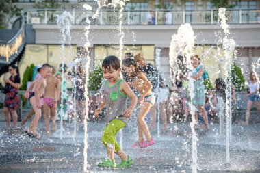 Kiev, Ukrayna 13 Ağustos 2017: Happy kids sıcak yaz gününde şehir su fıskiyede oynamak eğlenceli. Ebeveynler çocuklarıyla birlikte. Etkin aile boş, ekoloji kavramı.
