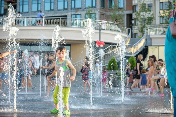 Kiev, Ukrayna 13 Ağustos 2017: Happy kids sıcak yaz gününde şehir su fıskiyede oynamak eğlenceli. Ebeveynler çocuklarıyla birlikte. Etkin aile boş, ekoloji kavramı.