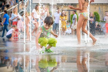 Kiev, Ukrayna 13 Ağustos 2017: Happy kids sıcak yaz gününde şehir su fıskiyede oynamak eğlenceli. Ebeveynler çocuklarıyla birlikte. Etkin aile boş, ekoloji kavramı.
