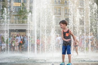 Kiev, Ukrayna 13 Ağustos 2017: Happy kids sıcak yaz gününde şehir su fıskiyede oynamak eğlenceli. Ebeveynler çocuklarıyla birlikte. Etkin aile boş, ekoloji kavramı.