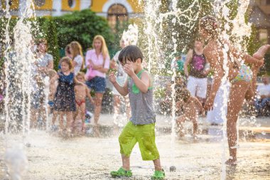 Kiev, Ukrayna 13 Ağustos 2017: Happy kids sıcak yaz gününde şehir su fıskiyede oynamak eğlenceli. Ebeveynler çocuklarıyla birlikte. Etkin aile boş, ekoloji kavramı.