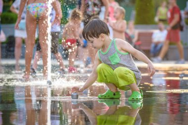 Kiev, Ukrayna 13 Ağustos 2017: Happy kids sıcak yaz gününde şehir su fıskiyede oynamak eğlenceli. Ebeveynler çocuklarıyla birlikte. Etkin aile boş, ekoloji kavramı.