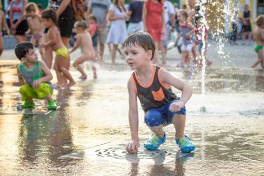 Kiev, Ukrayna 13 Ağustos 2017: Happy kids sıcak yaz gününde şehir su fıskiyede oynamak eğlenceli. Ebeveynler çocuklarıyla birlikte. Etkin aile boş, ekoloji kavramı.