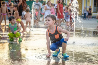 Kiev, Ukrayna 13 Ağustos 2017: Happy kids sıcak yaz gününde şehir su fıskiyede oynamak eğlenceli. Ebeveynler çocuklarıyla birlikte. Etkin aile boş, ekoloji kavramı.