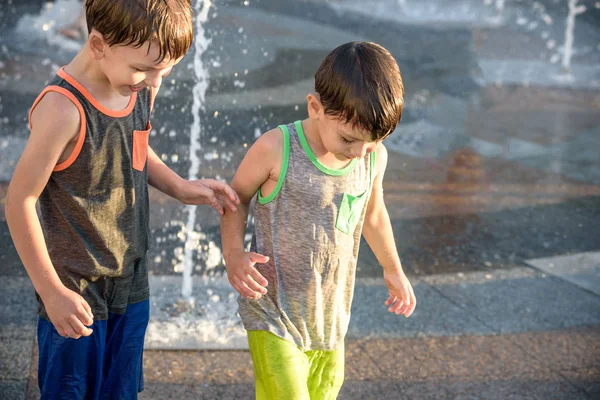 Mutlu çocuklar var şehir su çeşme sıcak yaz gününde oynayan eğlenceli. Çocuklar mutlu ve gülümseyen kardeşi arkadaşlarım. Ekoloji kavramı.