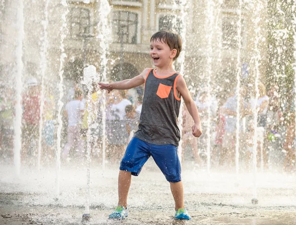 Heyecanlı çocuk su jetleri, Çeşme arasında eğleniyor. Şehirde yaz. Su ile el mutlu gülümseme yüz den vurdum. Ekoloji kavramı.