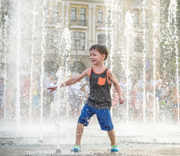 Heyecanlı çocuk su jetleri, Çeşme arasında eğleniyor. Şehirde yaz. Su ile el mutlu gülümseme yüz den vurdum. Ekoloji kavramı.