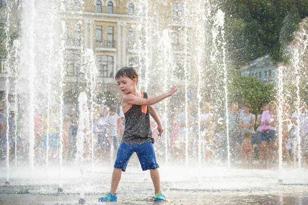 Heyecanlı çocuk su jetleri, Çeşme arasında eğleniyor. Şehirde yaz. Su ile el mutlu gülümseme yüz den vurdum. Ekoloji kavramı.