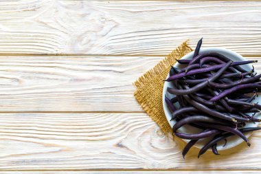 Ahşap ahşap arka plan tabağa mor dize fasulye.