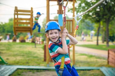 Genç çocuk oynamaya ve sahip eğlenceli aktiviteler açık havada yaptığını. Mutluluk ve mutlu çocukluk kavramı. İp salıncakta çocuk.