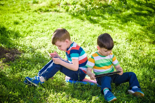 Dois Irmãos Estão Deitados Relva Com Tablet Menino Jogando Jogo — Fotografia de Stock