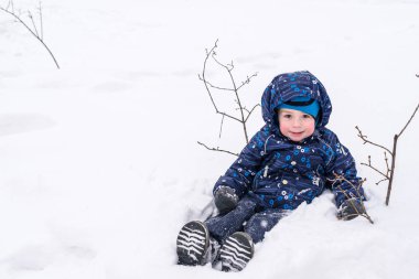 Küçük çocuk karda eğleniyor. sonra kar yağışı. etkin kış memnuniyetti zaman açık havada