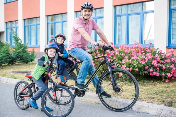 Family cycling, father with happy kid riding bike outdoors. Happy active sport leisure. Family are best friends. Young boy in baby seat. Toller on his bike.