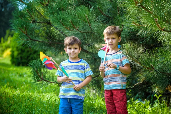 Yel Değirmeni Fırıldak Ile Bahçede Oynayan Iki Mutlu Çocuk Çok — Stok fotoğraf