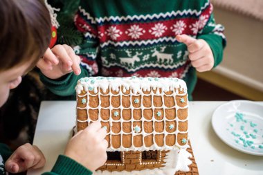 Zencefilli kurabiye ev, evde dekorasyon Noel ağacı önünde oynayan ve zevk, Noel kavramı çocuk yapma iki tatlı çocuklar, kardeşler,.