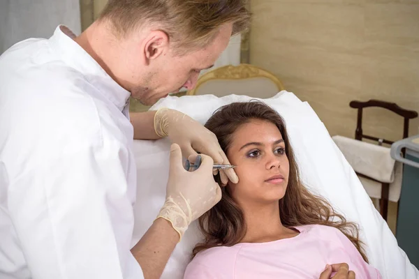 Hardware cosmetology, mesotherapy, Close up of young woman getting treatment of cheek zone at spa.