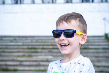 Korkmuş şaşırmış şaşkın karışık beyaz erkek çocuk güneş gözlüklü, tuğla beyaz duvar arka planı teşkil etmektedir. Beyaz çocuk modelleri açık havada heyecanlı.