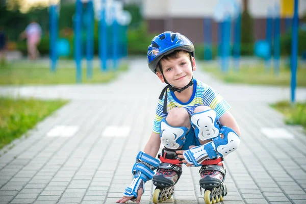 Satır içi paten ve koruyucu giysiler gülümseyen çocuk. Çocuk koruma vatkaları güvenli roller buz pateni binmek için. Çocuklar için etkin açık spor. Görünümü kapatın