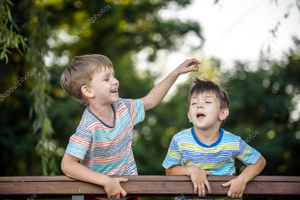 Two kids on the hiking, stand and look at the horizon surrounded by warm sunny colors. Concept of friendship between brothers, happy family.