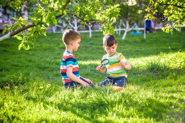 Güneşli bir günde elinde büyüteçle kağıt üzerinde ateş yakan iki sevimli çocuk. Bahçede ateş doğasını keşfeden çocuk. Büyüteci olan genç bir kaşif. Eğitim ve keşif kavramı