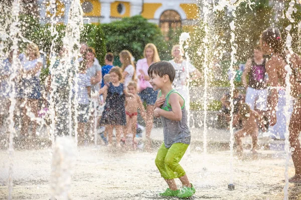 Garçon excité s'amuser entre les jets d'eau, dans la fontaine. Été i — Photo