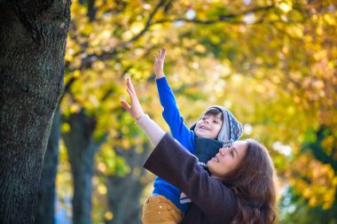 Sevimli, mutlu, güleryüzlü ve annesi arasında sarı l ile sarılma çocuk