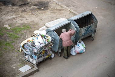Kiev, Ukrayna 31 Mart 2019: bir çöp yiyecek arayan bir evsiz adam çöp. Kentsel yoksulluk