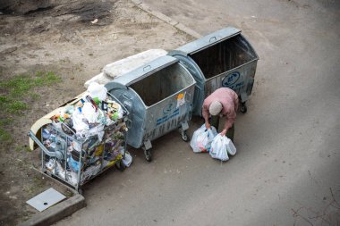 Kiev, Ukrayna 31 Mart 2019: bir çöp yiyecek arayan bir evsiz adam çöp. Kentsel yoksulluk