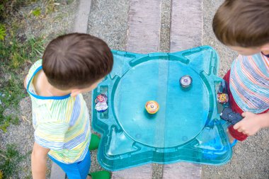 İki erkek bir Spinning üst çocuk oyuncak ile oynuyor. Popüler çocuk oyunu turnuvası. Yukarıdan görüntüle