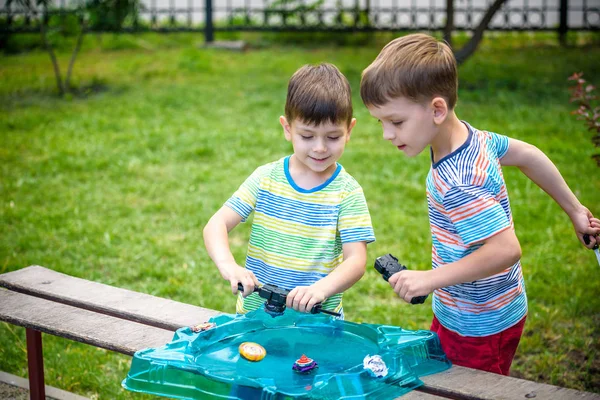 Two boys playing with a spinning top kid toy. Popular children g — Stock Photo, Image