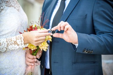 Yakın çekim. Gelin ve damat el. Gelin ve damat elele tutuşun. Yüzüklerin üzerinde odaklanın. Gelin el buketi