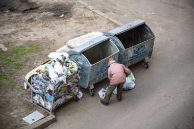 Kiev, Ukrayna 31 Mart 2019: bir çöp yiyecek arayan bir evsiz adam çöp. Kentsel yoksulluk