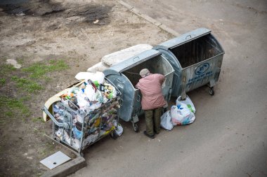 Kiev, Ukrayna 31 Mart 2019: bir çöp yiyecek arayan bir evsiz adam çöp. Kentsel yoksulluk