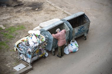 Kiev, Ukrayna 31 Mart 2019: bir çöp yiyecek arayan bir evsiz adam çöp. Kentsel yoksulluk