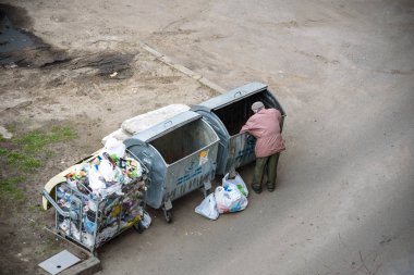Kiev, Ukrayna 31 Mart 2019: bir çöp yiyecek arayan bir evsiz adam çöp. Kentsel yoksulluk