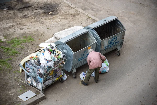 Kiev, Ukrayna 31 Mart 2019: bir çöp yiyecek arayan bir evsiz adam çöp. Kentsel yoksulluk