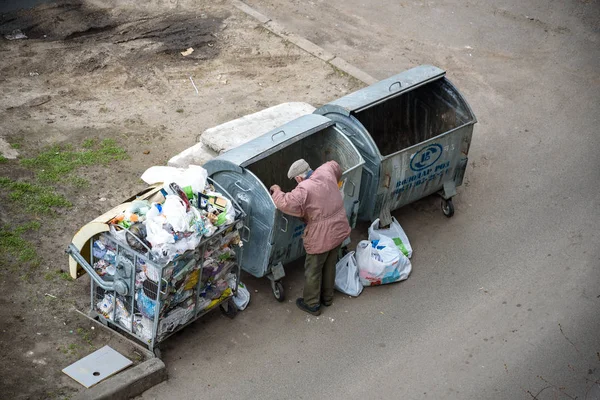Kiev, Ukrayna 31 Mart 2019: bir çöp yiyecek arayan bir evsiz adam çöp. Kentsel yoksulluk