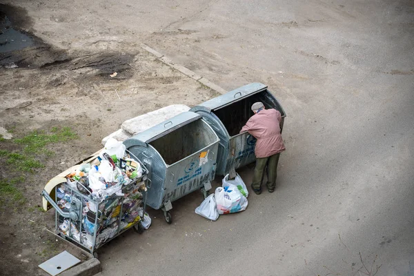 Kiev, Ukrayna 31 Mart 2019: bir çöp yiyecek arayan bir evsiz adam çöp. Kentsel yoksulluk