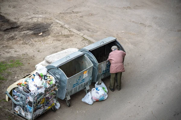 Kiev, Ukrayna 31 Mart 2019: bir çöp yiyecek arayan bir evsiz adam çöp. Kentsel yoksulluk