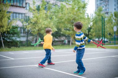 Oyuncak uçak mavi su karşı oynamaktan mutlu iki kardeş çocukları
