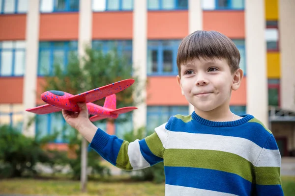 행복 한 꼬마 좋은 건물 배경 장난감 비행기와 함께 연주. 소년 학교 또는 유치원 필드에 던져 거품 비행기. 제일 어린 시절 개념 — 스톡 사진