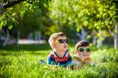 Mutlu gülümseyen çocuk kardeş kardeş çimenler üzerinde rahatlatıcı. Yakın u