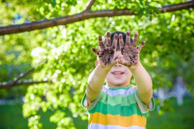 Kirli ellerini oynadıktan sonra gösterilen genç bir beyaz çocuk 