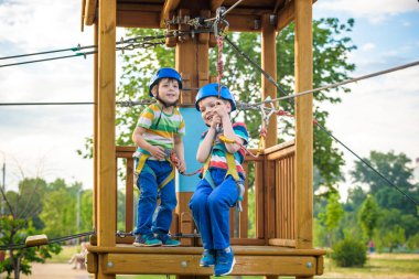 Macera parkında eğlenen mutlu çocuklar.